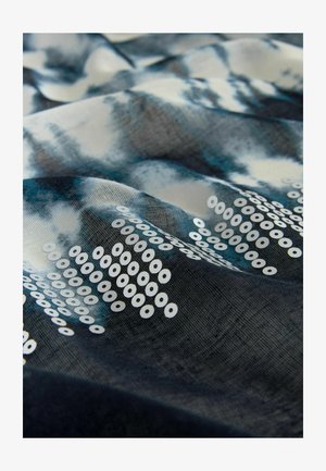 Kangas, millel on sinine ja valge tikkimise ääristustav, sisaldavad valget ringikujulist sädelust, mis on korraldatud geomeetriliste kujundite järgi kogu kanga pinnal.