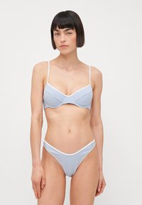 Striped bikini set featuring a soft white and blue color scheme, with adjustable straps and a twisted bandeau design on the top.
