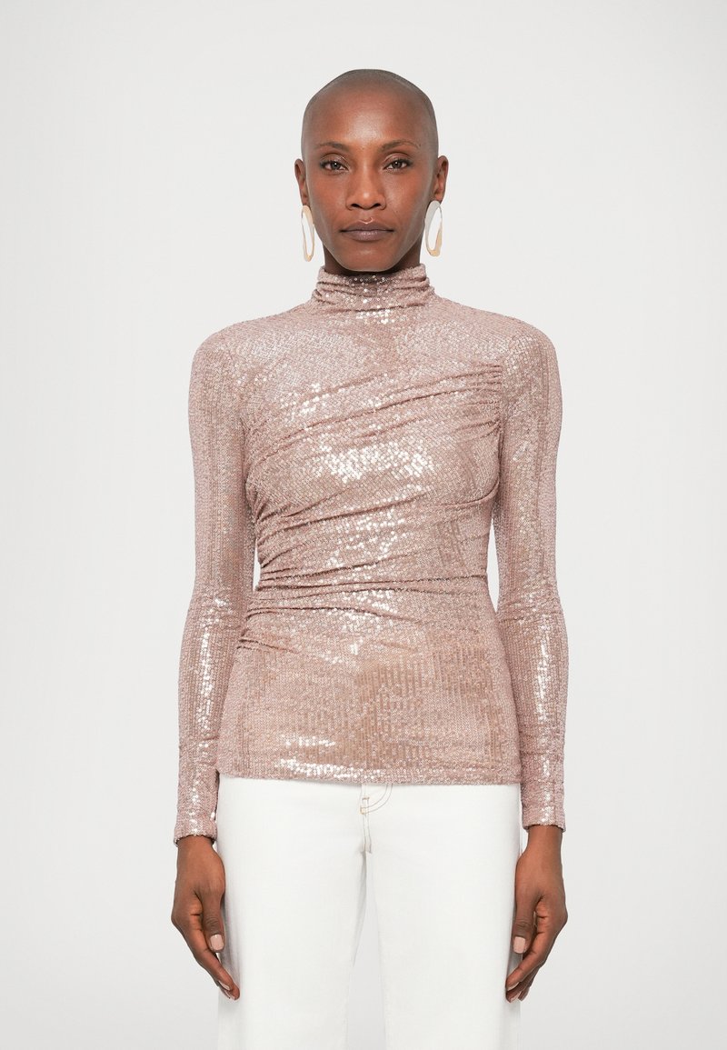 Λαμπερό ροζ χρυσό μπλουζάκι με μακριά μανίκια και ψηλό λ�αιμό, που διαθέτει τσακισμένα υφασμάτινα στοιχεία και εφαρμοστή σιλουέτα, συνδυασμένο με λευκά τζιν.