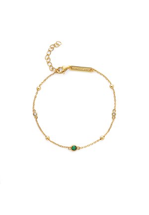 Pulsera de cadena dorada con pequeñas cuentas redondas, una piedra verde central y un cierre de langosta con una etiqueta grabada con la palabra "SINGULAR".