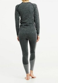 Top sportivo grigio e leggings con un motivo testurizzato. Adatti alla forma, maniche lunghe e pantaloni lunghi fino alla caviglia, con accenti a contrasto.