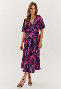 Fioletowa sukienka w kwiaty z krótkimi rękawami, z mieszanką różowych i niebieskich wzorów. Wykonana z jedwabistego materiału, sięga poniżej kolan.