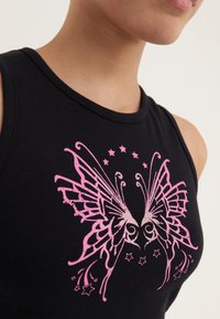 Top negro de tirantes con un gráfico de mariposa rosa brillante, detalles en espiral y estrellas, hecho de un material suave y elástico.