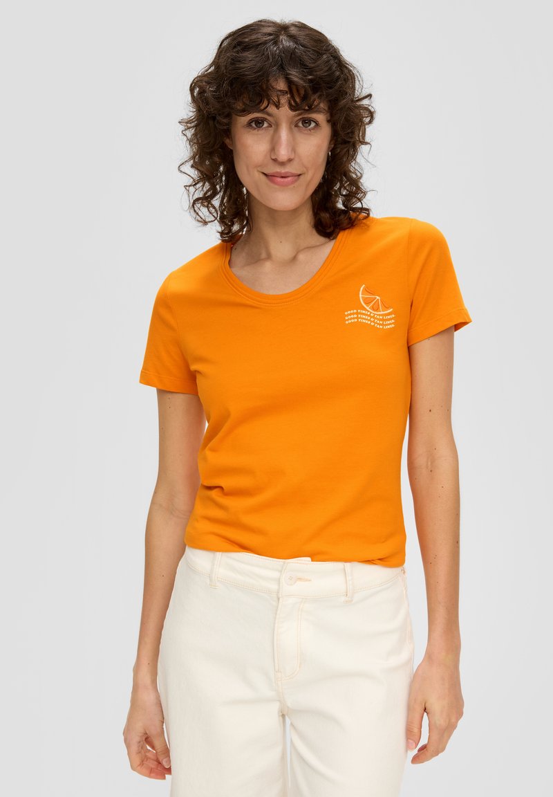 T-shirt en coton orange avec un col rond et des manches courtes, arborant un texte graphique blanc et un design de tranche de citron sur la poitrine.