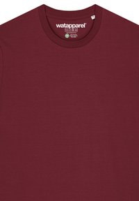 Bordeauxfarbenes T-Shirt aus weicher Baumwolle mit rundem Halsausschnitt und einem Etikett mit der Marke "Wat Apparel" im Kragen.
