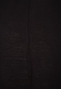 Tejido de punto negro con una textura suave y ligeramente brillante. Presenta una costura sutil que recorre verticalmente el centro.