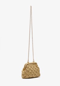 Woven straw handbag in light beige with a metal chain strap, featuring a rounded top and decorative textured pattern.