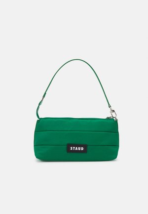Green quilted handbag with a smooth texture, featuring a short strap and a rectangular shape. It has a black logo patch on the front.