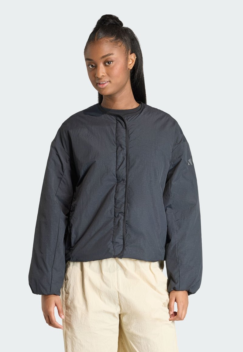 Čierna prešívaná bunda s okrúhlym výstrihom, dlhými rukávmi a predným zapínaním. Hladká textúra s minimalistickými dizajnovými detailmi.