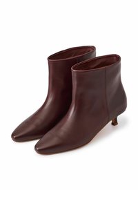 Botas de tobillo de cuero burdeos con punta afilada, textura suave, forma cónica y tacón bajo. Diseño minimalista con costuras sutiles.