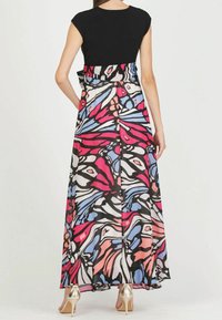 Maxiklänning med svart topp med korta ärmar och ett färgglatt blommönster i rosa, blått och svart. Har en inhägnad midja och en svängig kjol.