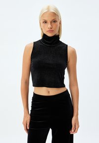 Top nero senza maniche a collo alto, realizzato in tessuto lucido con un design avvitato. L'orlo è tagliato appena sopra la vita, evidenziando una superficie liscia.