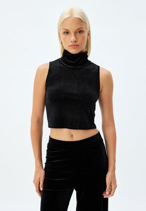 Top negro sin mangas con cuello alto, hecho de una tela brillante y de diseño ajustado. El dobladillo es corto, justo por encima de la cintura, lo que resalta una textura suave.