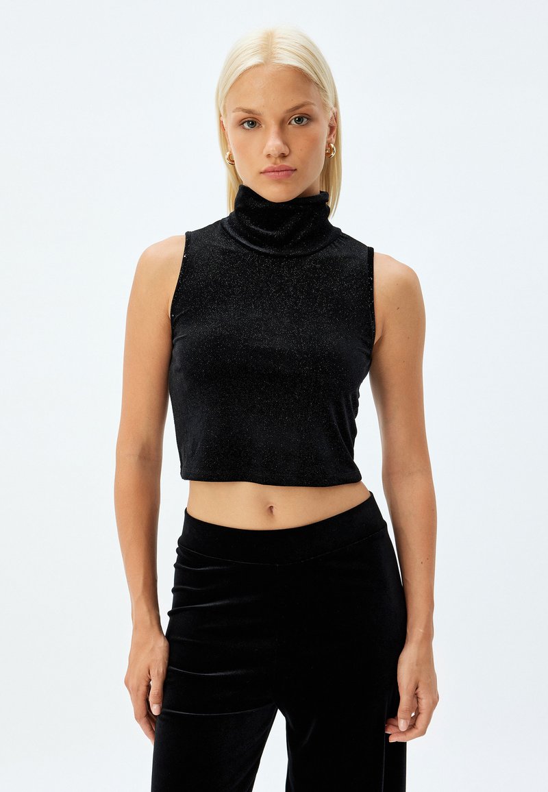 Top nero senza maniche a collo alto, realizzato in tessuto lucido con un design avvitato. L'orlo è tagliato appena sopra la vita, evidenziando una superficie liscia.