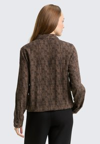 Braun gestreiftes Langarmhemd mit Kragen und geknöpften Manschetten. Verfügt über einen texturierten Stoff mit vertikalen Linien und einer lässigen Passform.