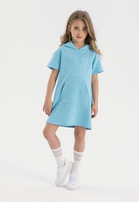 Rochie hanorac bleu deschis cu un buzunar frontal, având textul embosat "NYC". Asortată cu adidași albi și șosete până la genunchi cu dungi colorate.