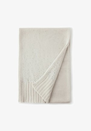 Stickad sjal i ljus beige med silverdekorationer. Har en ribbad kant och ett vikt hörn som visar en texturerad yta.