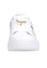 Baskets blanches à semelle épaisse, lacets blancs avec un accessoire en forme de libellule dorée, et panneaux latéraux argentés pailletés.