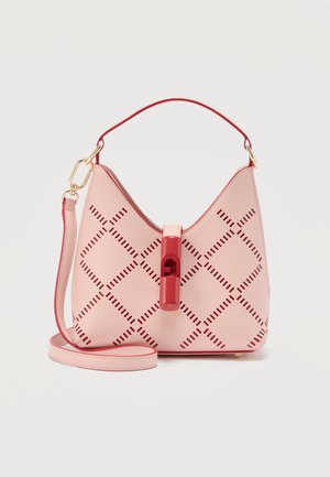 Petit sac à main rose clair avec des perforations géométriques rouges, une poignée supérieure rouge et une bandoulière amovible posés devant sur un fond blanc.