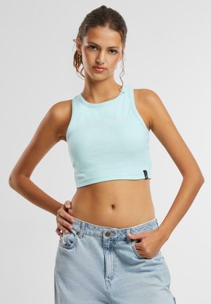Lys blå ribbet crop tank top med rund halslinning. Har brodert tekst på forsiden og en liten svart merkelapp nederst.