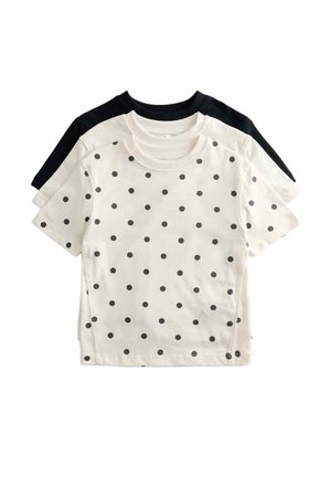 Tres camisetas de manga corta con cuello redondo apiladas, la superior en blanco con lunares negros, la del medio lisa en blanco y la trasera lisa en negro.