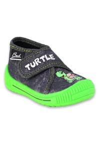 Zwarte stoffen schoen met groene rubberen zool. Heeft een klittenbandriem en een schildpadafbeelding. "TURTLE" tekst in het wit op de bovenkant.