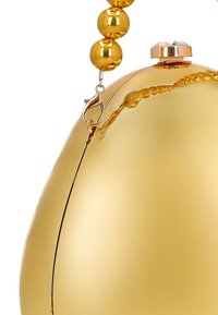 Złota kopertówka o jajowatym kształcie, gładkie matowe wykończenie, ozdobny pasek z błyszczących, okrągłych koralików oraz dekoracyjna zapinka z kamieniem szlachetnym.