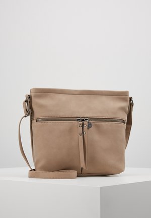 Béžová crossbody kabelka s předním kapsou na zip, dvěma jezírky na zip a nastavitelným popruhem na bílém povrchu na jednobarevném pozadí.