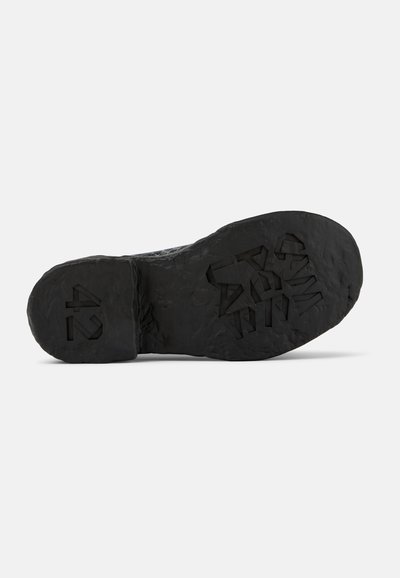 Black shoe sole with textured rubber surface, featuring a distinct pattern and marked size "42" on the side. Durable and flat design.