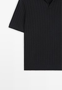 Schwarzes Kurzarm-Strickshirt mit vertikal gerippter Struktur und V-Ausschnitt, flach liegend dargestellt mit sichtbarem linkem Ärmel.