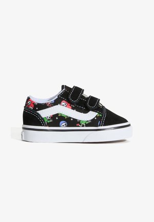 Schwarz-weißer Kindersneaker mit zwei Klettverschlüssen und bunten Cartoon-Schädeln in Rot, Blau und Grün an den Seiten.