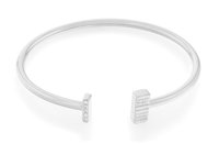Bracciale rigido in argento con due estremità geometriche, una con finitura lucida e l'altra decorata con cinque piccole pietre trasparenti.