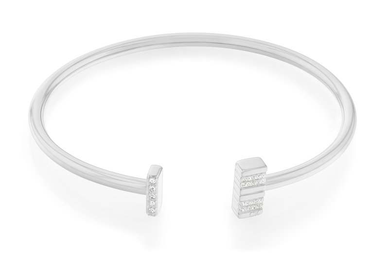 Bracciale rigido in argento con due estremità geometriche, una con finitura lucida e l'altra decorata con cinque piccole pietre trasparenti.