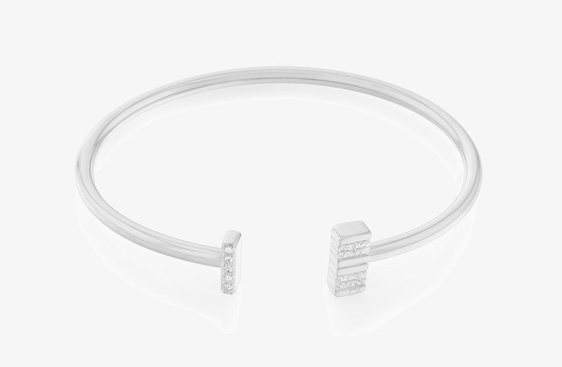 Pulsera de plata con extremos geométricos, uno con acabado pulido y el otro adornado con cinco pequeñas piedras claras.