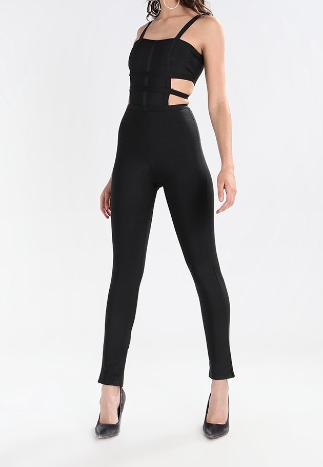 Svart jumpsuit med figurnära överdel, utskurna sidor och smala ben. Tillverkad av ett slätt tyg, med spagettiband och hög halsringning.