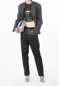 Top corto de cuero negro, blazer gris de gran tamaño, jeans negros con dobladillo deshilachado, clutch plateado y tacones de estampado de serpiente. Texturas suaves y diseño audaz.