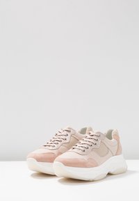 Tenisky s horní částí z jemného růžového semiše a síťoviny, s plochými tkaničkami, polstrovanou bílou podrážkou a zaobleným designem špičky.