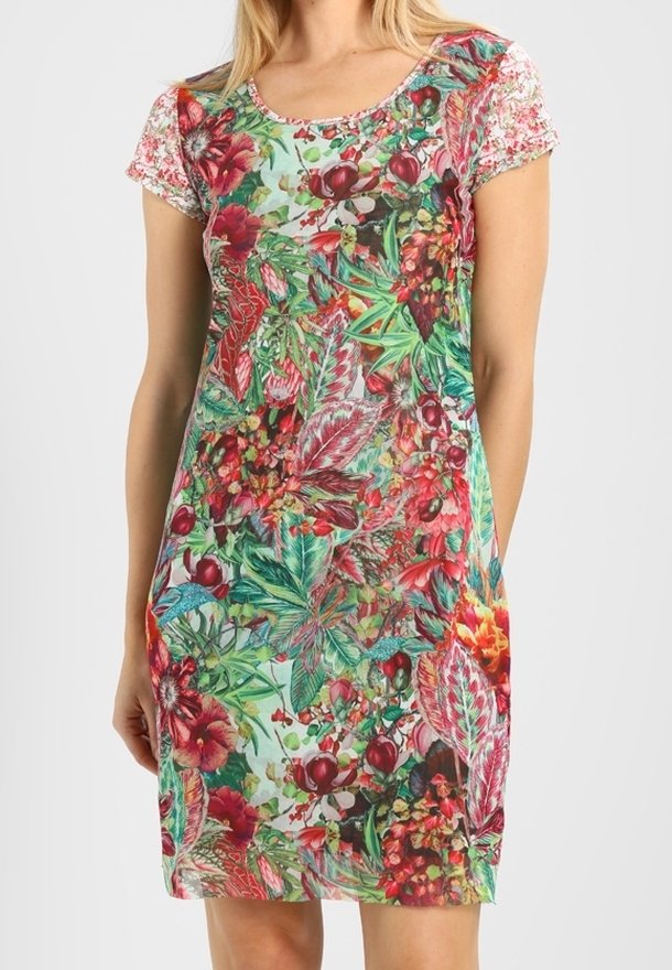 Femme portant une robe à manches courtes, longueur genou, avec un motif floral et feuillu vif aux tons rouges, verts et roses.