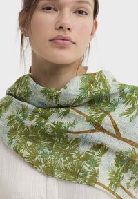 Écharpe légère avec un motif d'arbres vert et bleu sur un fond texturé. Le tissu a une apparence douce et transparente.