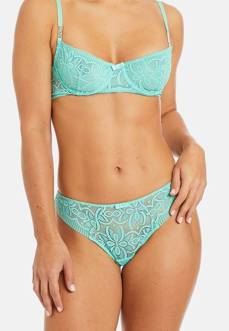 Soutien-gorge en dentelle bleu clair et culotte assortie avec des motifs floraux. Bretelles réglables et accent nœud sur le soutien-gorge. Texture douce et transparente.