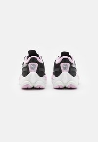 Une paire de chaussures de course Puma noires et roses vue de l'arrière, montrant des semelles blanches texturées et le logo sur les languettes de talon.