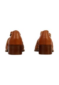Brown leather shoes with a low stacked heel, featuring a strap with a small buckle and open side detailing, smooth texture, and simple design.