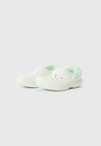 Weiße Clogs zum Hineinschlüpfen mit belüfteten Löchern und einem leicht grünen Plüschfutter, ausgestattet mit einem Fersenriemen für einen sicheren Sitz.