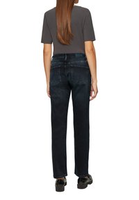 Hoge taille, rechtlopende jeans van donkerdenim met een subtiele textuur. Beschikt over twee achterzakken en een klein logo op de tailleband.
