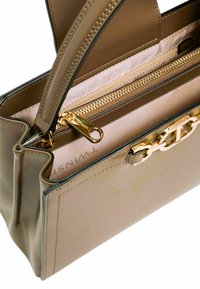 Borsa a mano in pelle marrone con cerniera dorata, design strutturato e interno leggero a contrasto con un dettaglio logo.