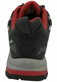 Graues und rotes Sportschuh-Modell mit strukturiertem Obermaterial, gepolstertem Schaft, reflektierenden Akzenten und einer stabilen Gummisohle.