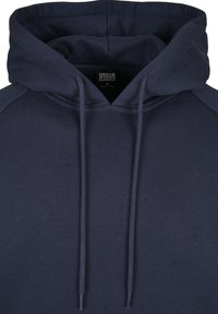 Marineblå hettegenser med stor snorhette, ribbede ermer og myk, strukturell stoff. Har et merke merket "URBAN CLASSICS."