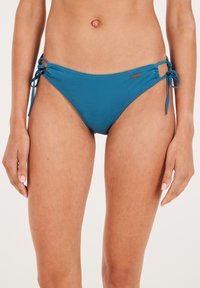 Teal bikini donji dio napravljen od glatkog materijala, s podesivim bočnim vezicama i malim logom. Dizajn s srednjim strukom s minimalnim prekrivanjem.
