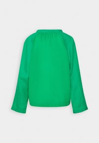 Camisa verde de manga larga hecha de tela ligera. Presenta un escote redondeado con fruncidos en la parte trasera y mangas ligeramente entalladas.