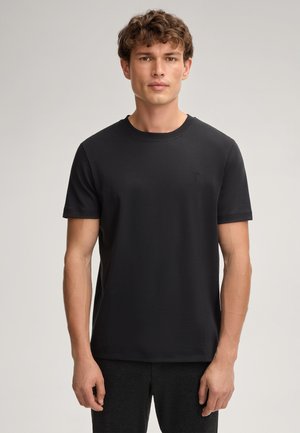 Schwarzes Crew-Neck-T-Shirt aus glattem Stoff. Kurze Ärmel, minimalistisches Design, dezentes Logo auf der Brust, normale Passform.